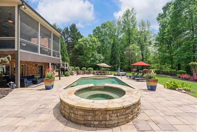outdoor pool featuring a sunroom, an in ground hot tub, an outdoor hangout area, and a patio area