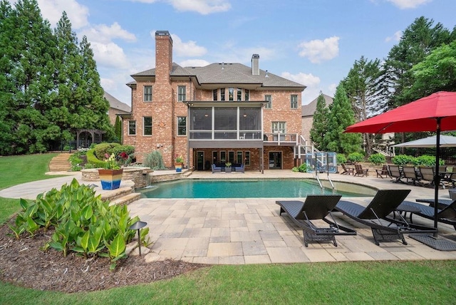 outdoor pool with stairs, a sunroom, and a patio