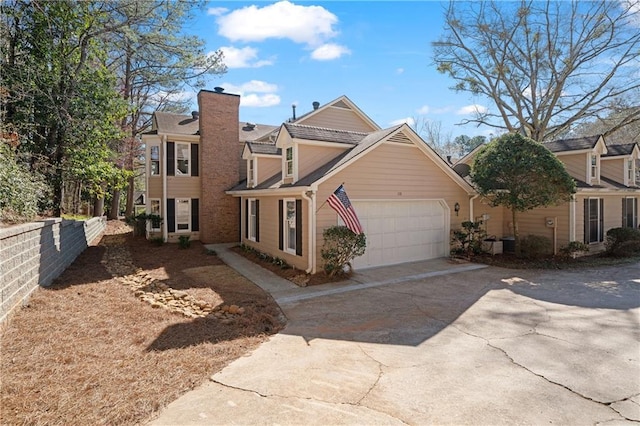 multi unit property with driveway, an attached garage, a chimney, and fence