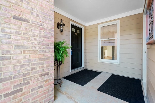 entrance to property featuring covered porch and brick siding