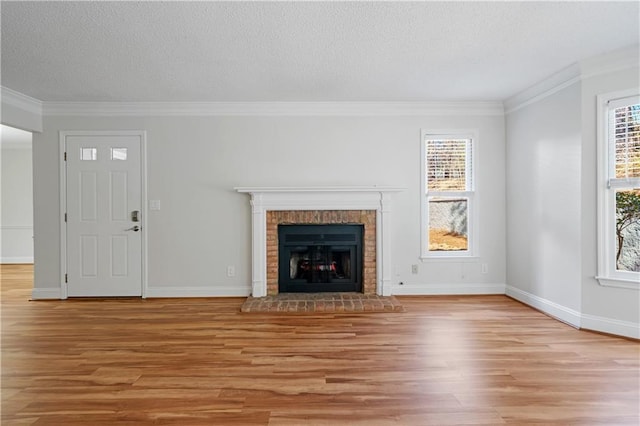 unfurnished living room featuring a wealth of natural light, crown molding, and light wood finished floors