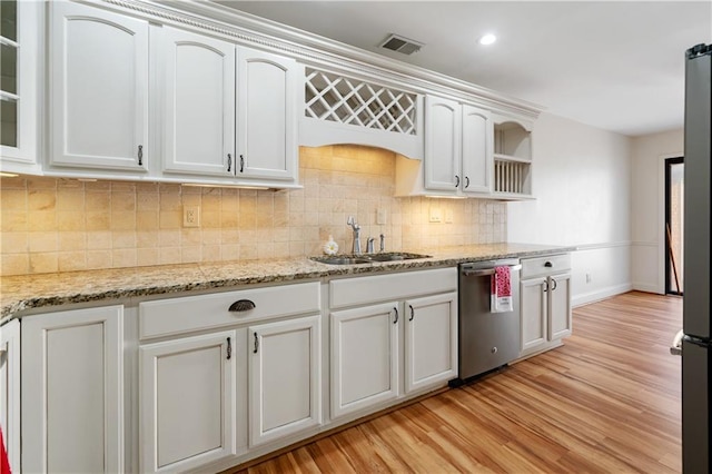 kitchen with a sink, visible vents, light wood-style floors, stainless steel dishwasher, and tasteful backsplash