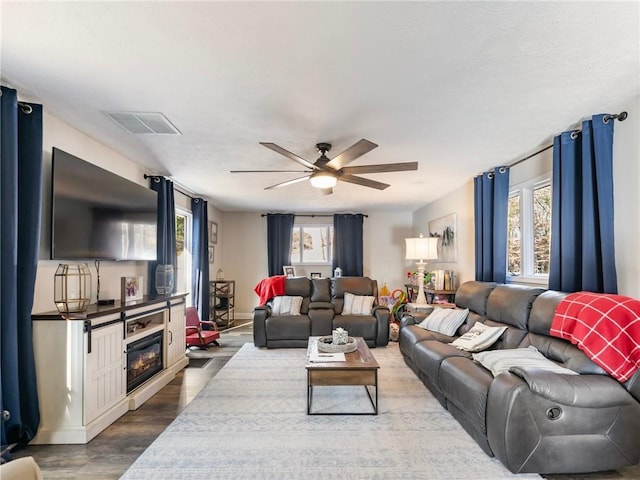 living room featuring wood-type flooring and ceiling fan