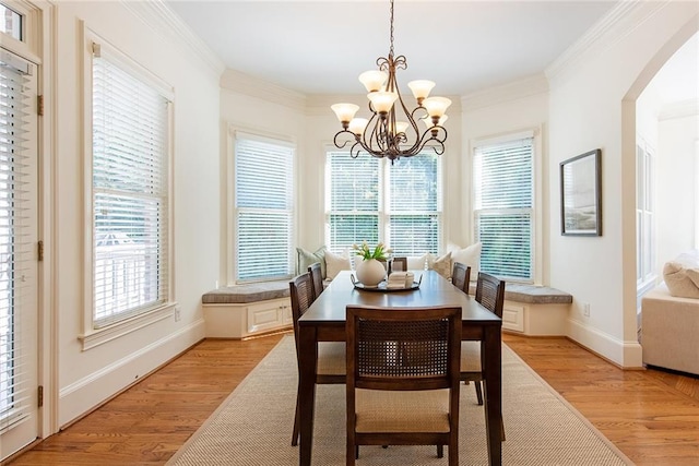 dining room featuring a notable chandelier, ornamental molding, and light hardwood / wood-style flooring