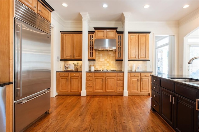 kitchen featuring built in fridge, light wood-type flooring, sink, and crown molding