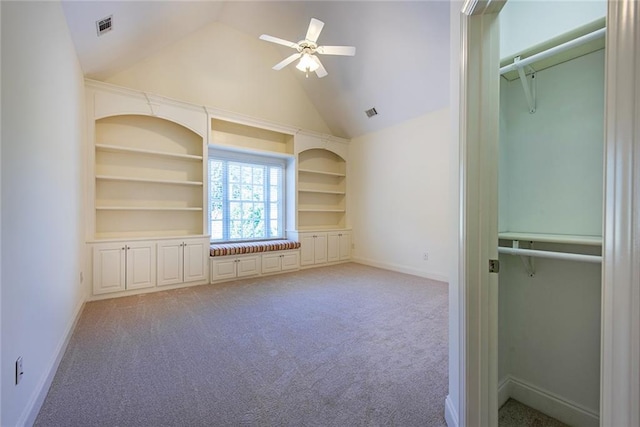 interior space with built in features, lofted ceiling, carpet, and ceiling fan