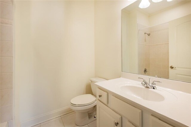 bathroom featuring toilet, vanity, tile patterned floors, and a tile shower