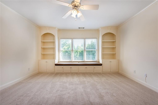 unfurnished living room featuring built in features, light colored carpet, and ornamental molding