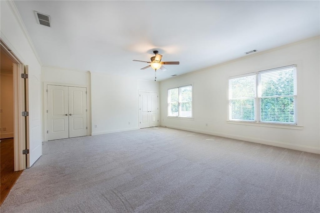 spare room featuring ornamental molding, carpet flooring, and ceiling fan