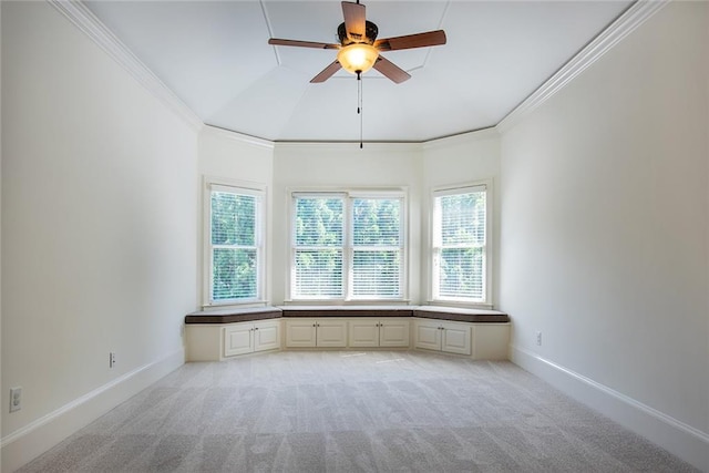 carpeted spare room with ceiling fan, crown molding, and vaulted ceiling