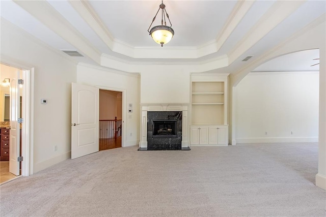 unfurnished living room featuring a premium fireplace, light colored carpet, and ornamental molding