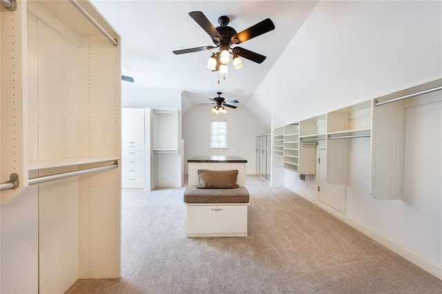 walk in closet featuring vaulted ceiling, light carpet, and ceiling fan