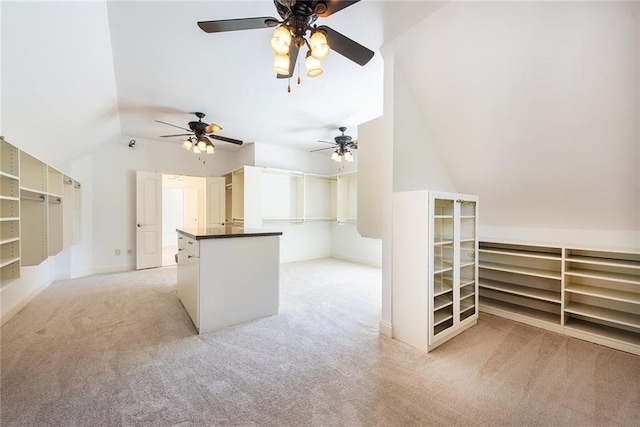 interior space with ceiling fan, light colored carpet, and vaulted ceiling