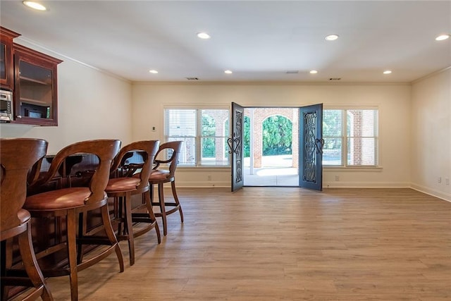 bar featuring ornamental molding and hardwood / wood-style floors