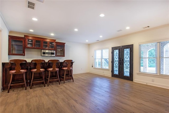 bar featuring dark wood-type flooring and crown molding