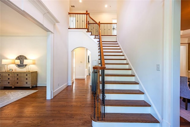 stairs featuring ornamental molding and hardwood / wood-style floors