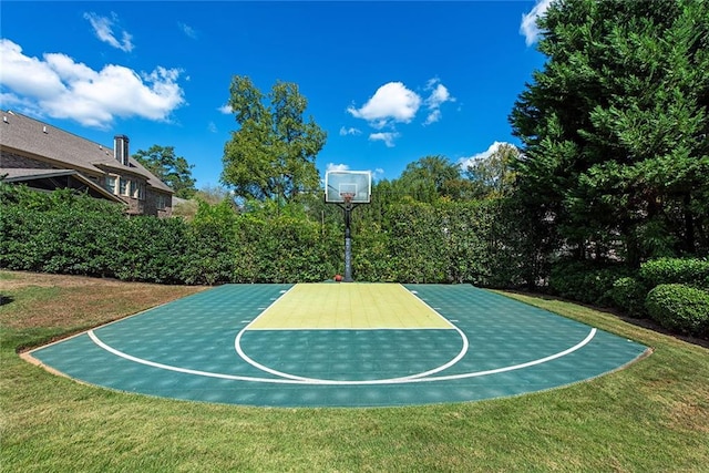 view of basketball court with a yard