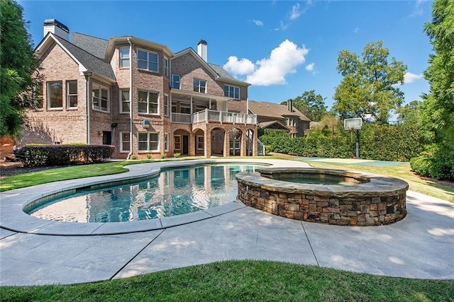 view of swimming pool featuring an in ground hot tub