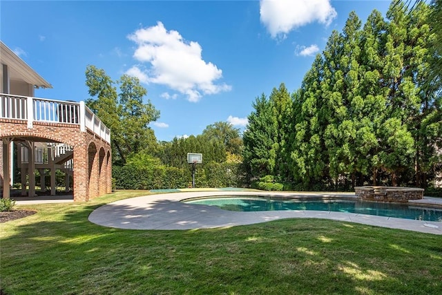 view of pool featuring a lawn and an in ground hot tub