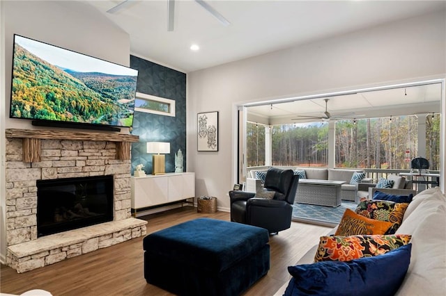 living room featuring wood finished floors, recessed lighting, a fireplace, a sunroom, and a ceiling fan