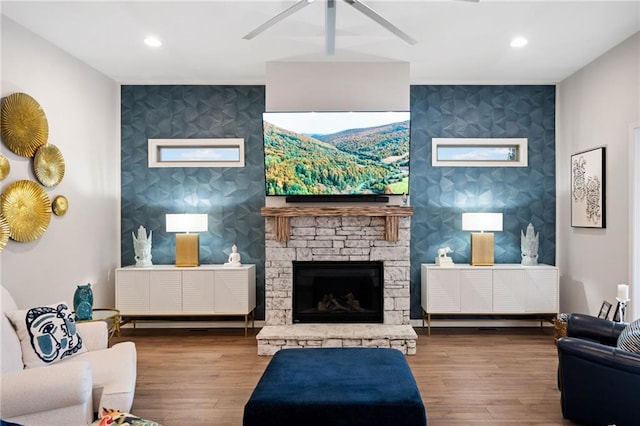 living area featuring wallpapered walls, an accent wall, and wood finished floors