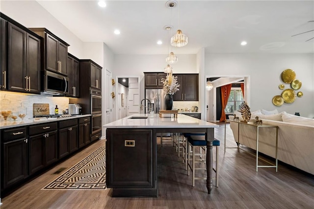 kitchen with a kitchen breakfast bar, tasteful backsplash, appliances with stainless steel finishes, and open floor plan