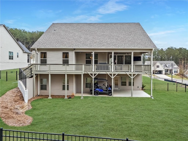 back of house featuring a fenced backyard, a lawn, a shingled roof, and a patio