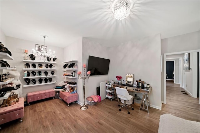 office area featuring a chandelier, baseboards, and wood finished floors