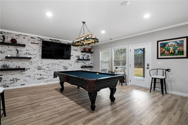 recreation room with light wood finished floors, crown molding, and baseboards