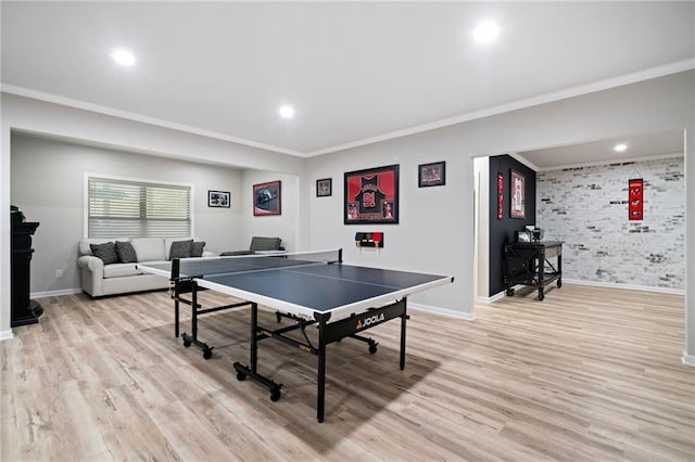 game room with light wood-type flooring, brick wall, and ornamental molding