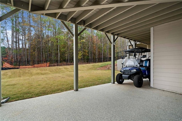 view of patio / terrace featuring a forest view and fence