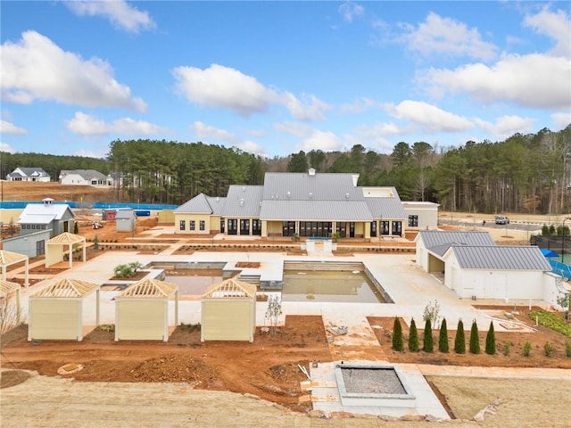 back of property with a swimming pool, a patio, and an outdoor fire pit