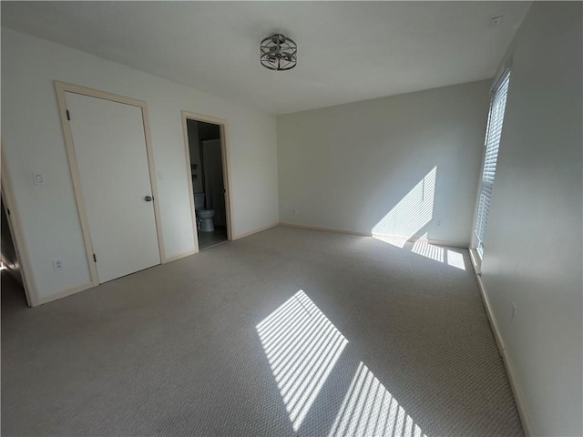 carpeted spare room featuring a wealth of natural light and baseboards