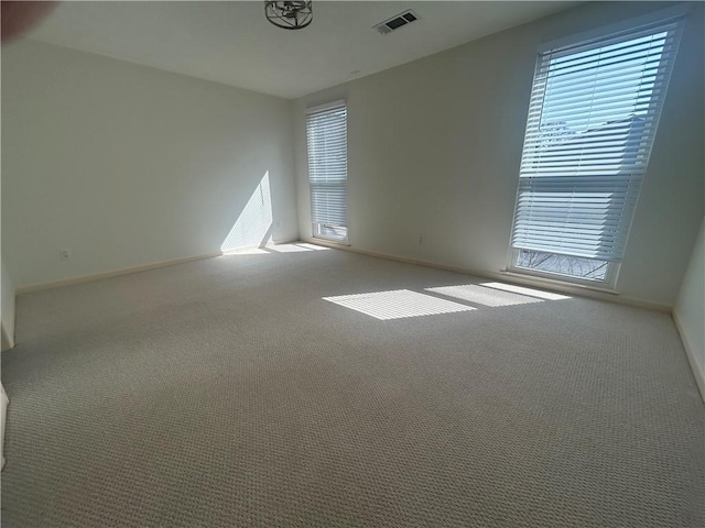 unfurnished room featuring visible vents, baseboards, and carpet floors