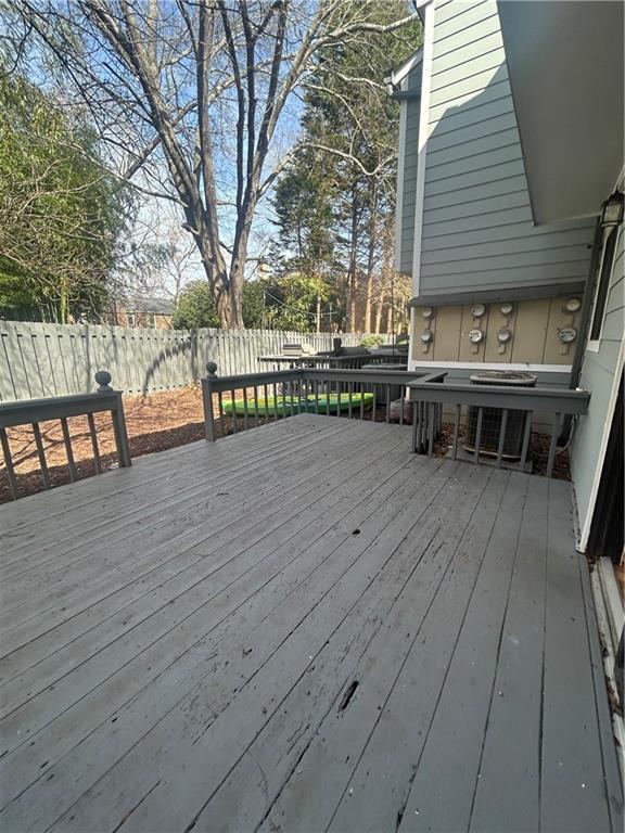 wooden deck featuring cooling unit and fence