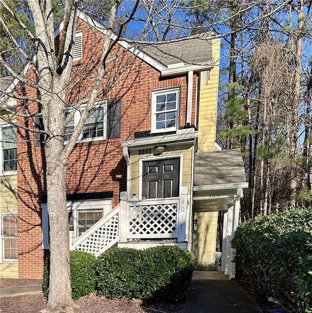 view of front of house featuring a chimney and brick siding