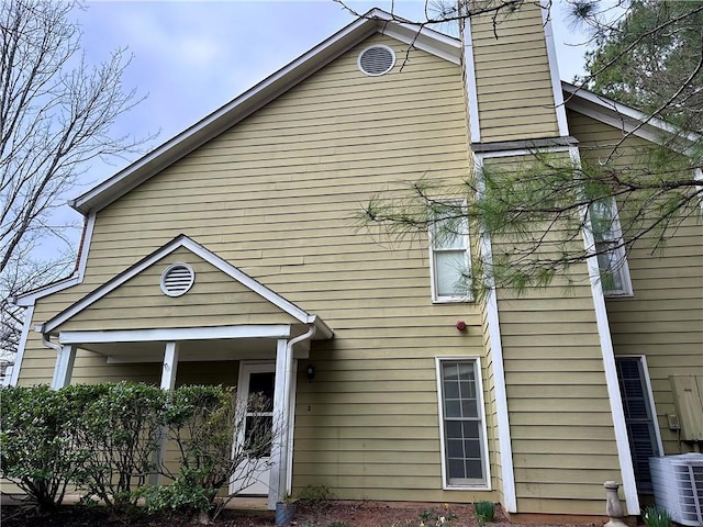 view of front of home with a chimney and central AC unit