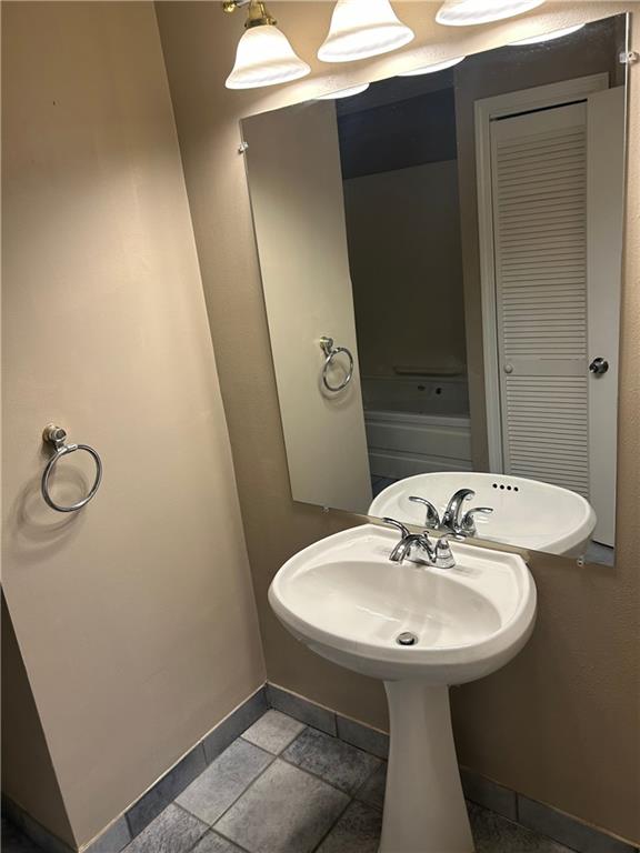 bathroom featuring baseboards and a sink