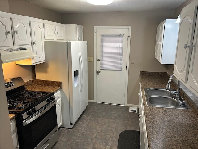 kitchen featuring dark countertops, under cabinet range hood, stainless steel gas stove, white cabinetry, and a sink