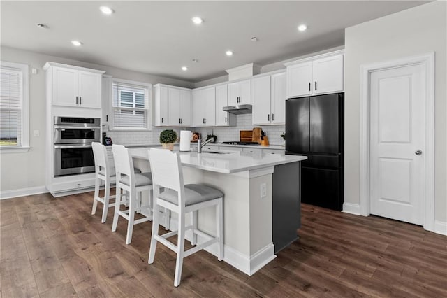 4011 Fallen Leaf Ct, Kennesaw, GA 30152 - kitchen featuring black appliances, a center island with sink, dark wood-style floors, decorative backsplash, and recessed lighting