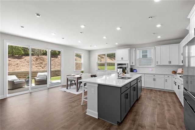 4011 Fallen Leaf Ct, Kennesaw, GA 30152 - kitchen with white cabinetry, a kitchen island with sink, dark wood-style floors, plenty of natural light, and recessed lighting