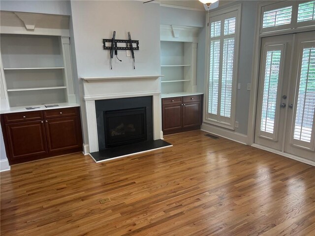 2380 Crescent Park Ct Unit 4, Atlanta, GA 30339 - unfurnished living room with wood finished floors, built in shelves, a fireplace with raised hearth, and baseboards