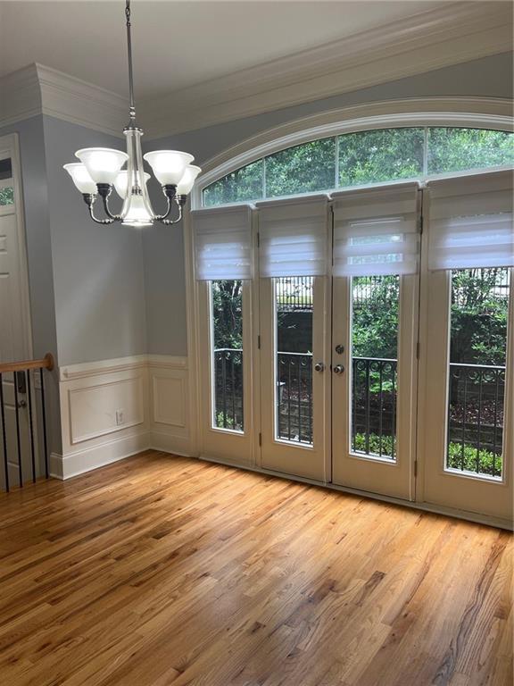 2380 Crescent Park Ct Unit 4, Atlanta, GA 30339 - unfurnished dining area with wood finished floors, a chandelier, plenty of natural light, ornamental molding, and a wainscoted wall