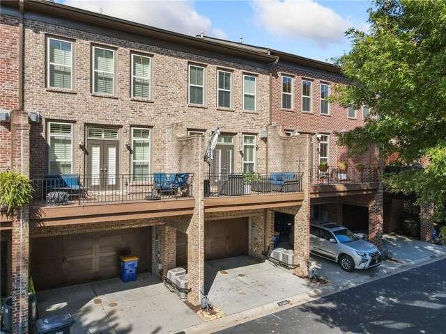 2380 Crescent Park Ct Unit 4, Atlanta, GA 30339 - rear view of house featuring an attached garage, brick siding, and concrete driveway