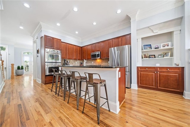 2380 Crescent Park Ct Unit 4, Atlanta, GA 30339 - kitchen with appliances with stainless steel finishes, a breakfast bar area, light wood-style floors, tasteful backsplash, and crown molding