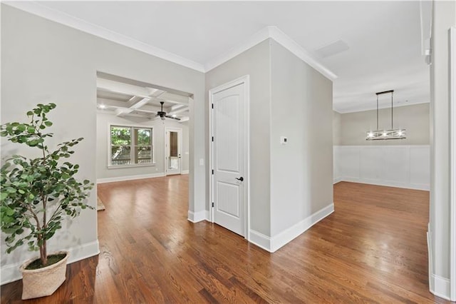 hall featuring coffered ceiling, wood-type flooring, ornamental molding, a notable chandelier, and beam ceiling