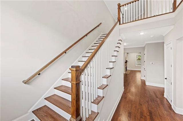 staircase featuring wood-type flooring and crown molding