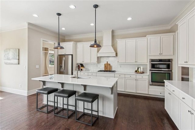 673 Dunbrody Dr, Milton, GA 30004 - kitchen featuring appliances with stainless steel finishes, custom range hood, a sink, a kitchen breakfast bar, and light countertops