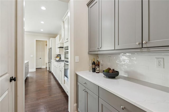 673 Dunbrody Dr, Milton, GA 30004 - kitchen featuring gray cabinets, decorative backsplash, dark wood-type flooring, stainless steel appliances, and crown molding