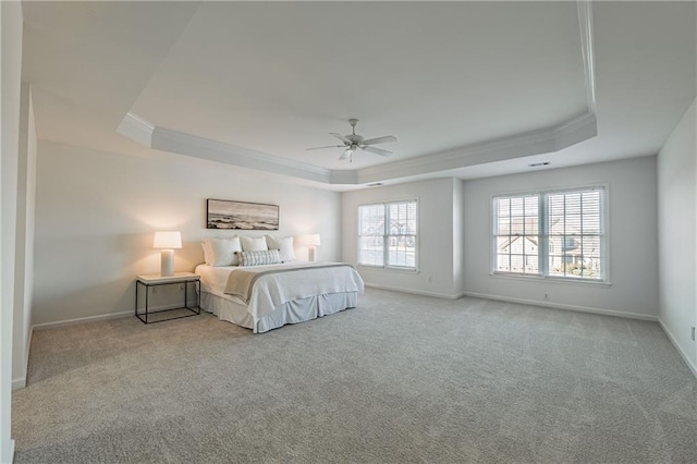 carpeted bedroom with baseboards, crown molding, a tray ceiling, and a ceiling fan